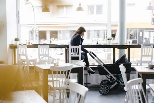 Businesswoman working at a cafe with her baby