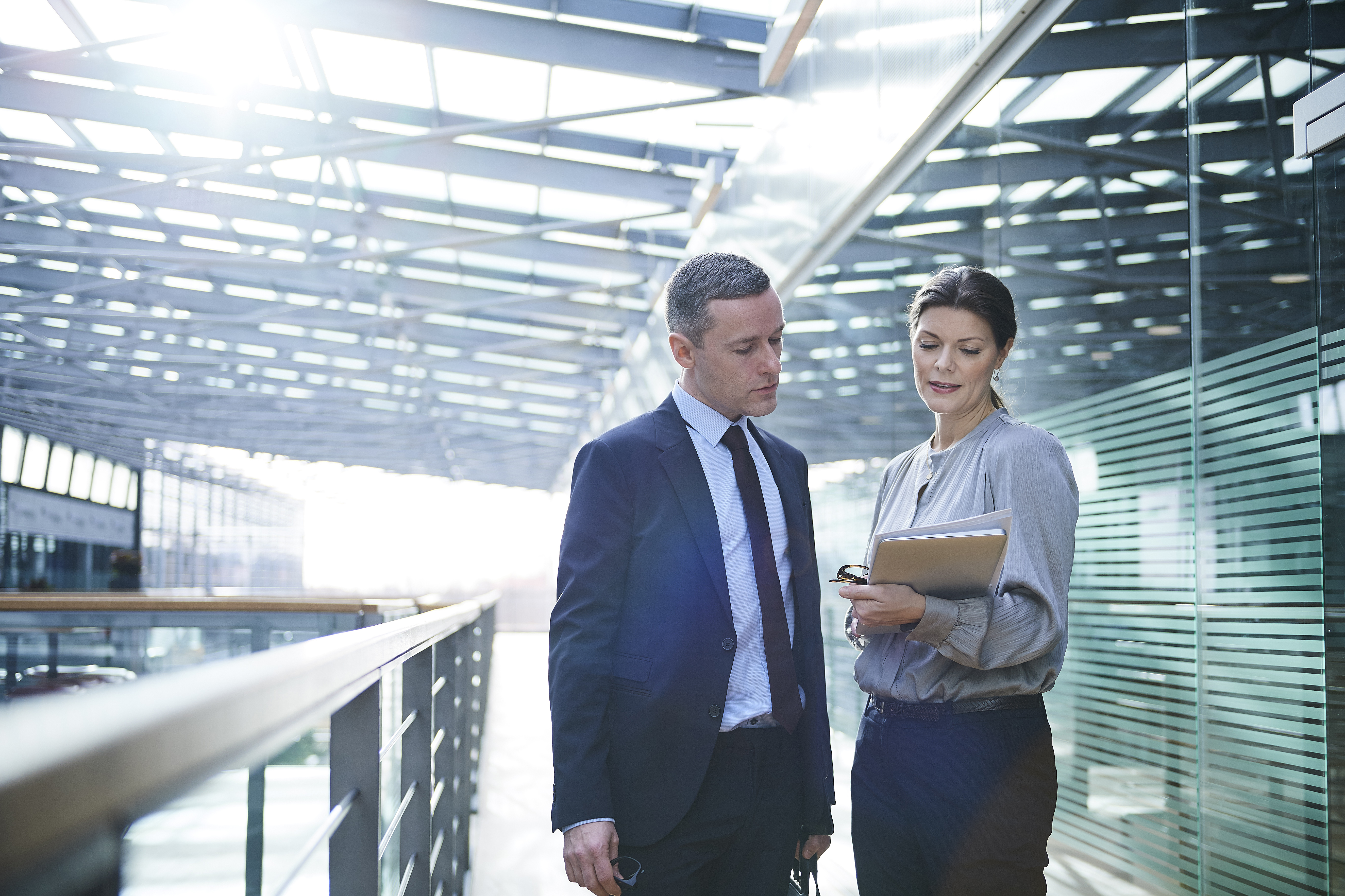 Businesswoman and businessman reading paperwork