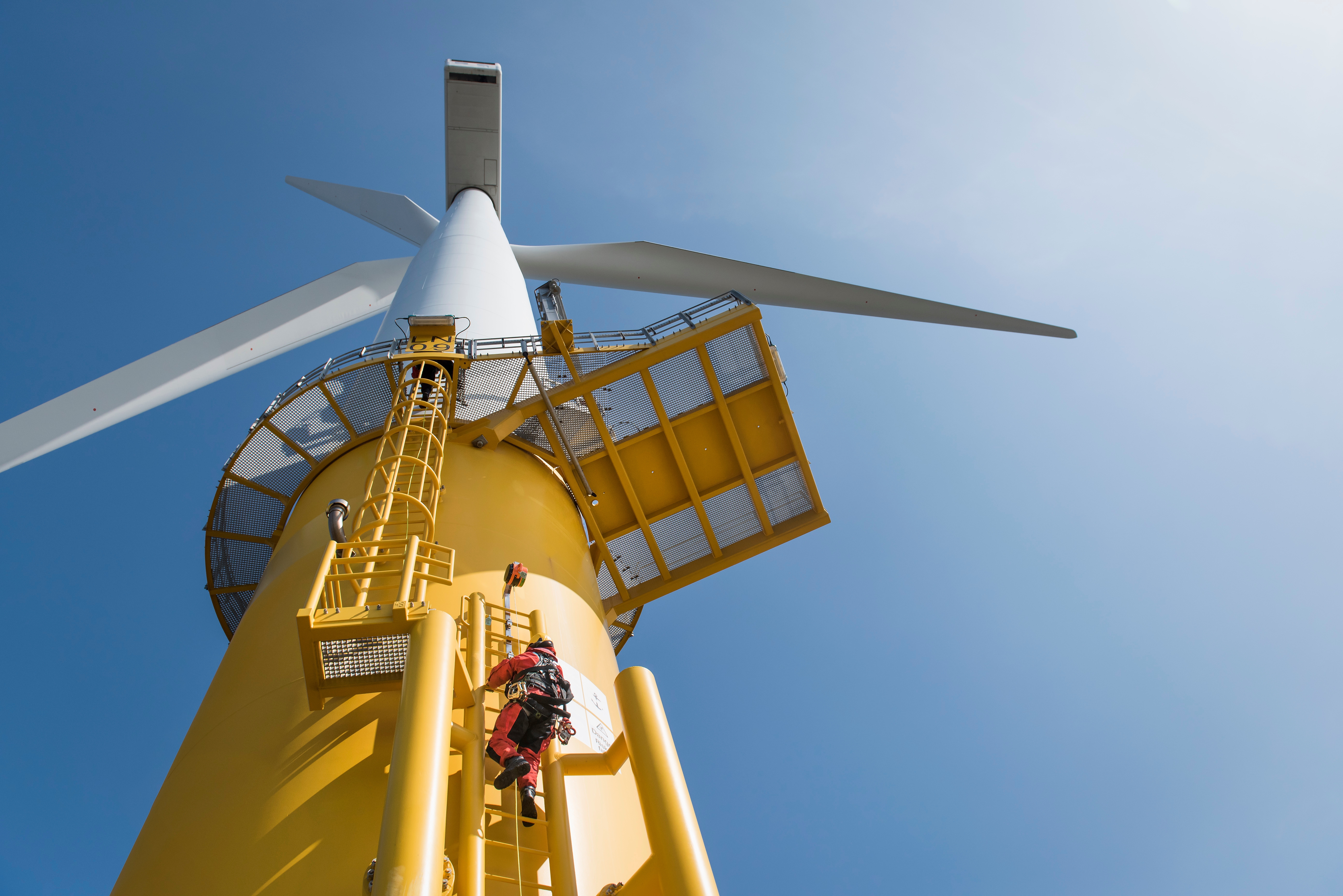 engineer climbing an offshore wind turbine