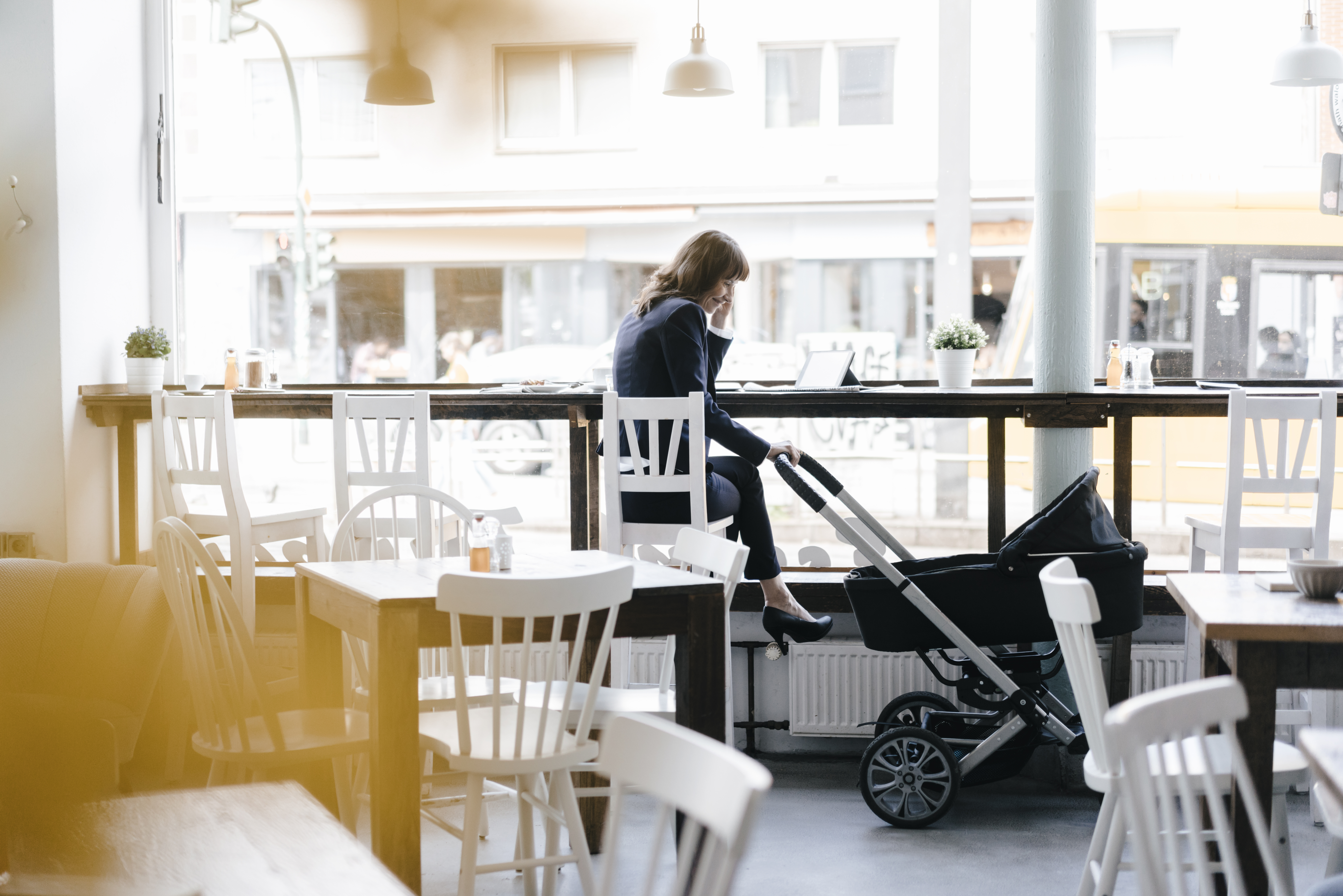 Businesswoman working at a cafe with her baby